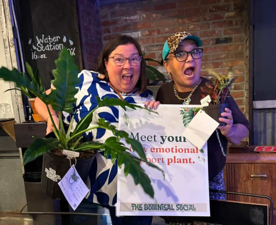Two friends showing off their plant prizes