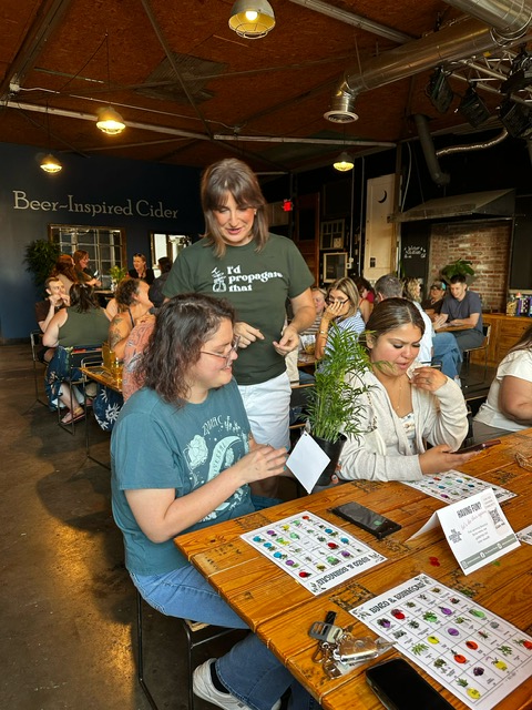 A guest holding her new plant prize at bingo night